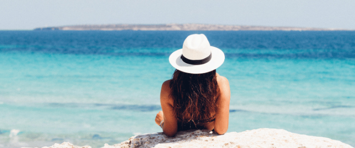 Person lying on the beach looking at the ocean