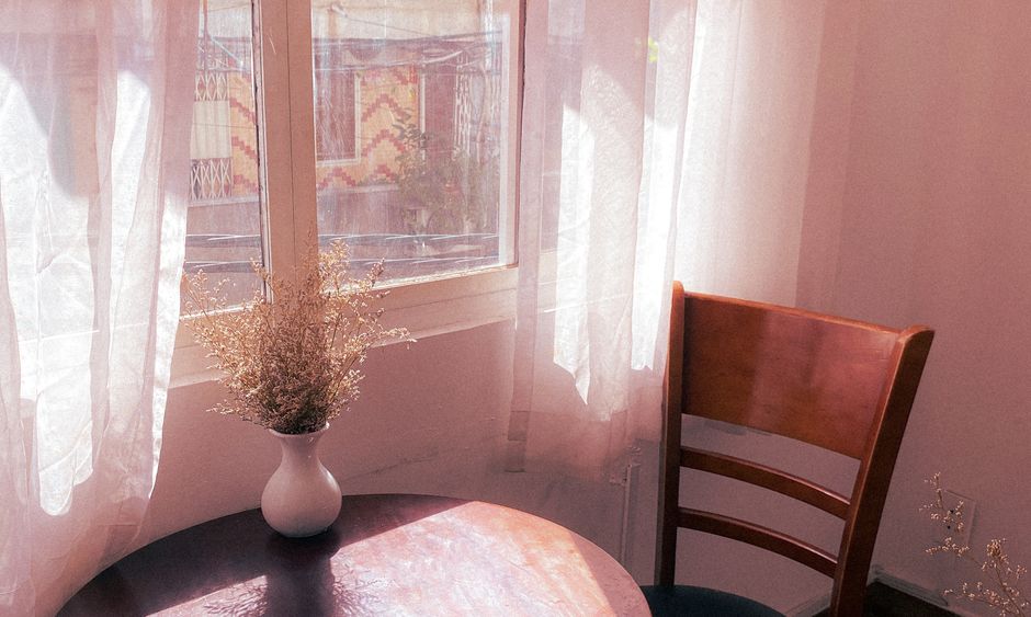 Sunlight streams into a beautifully decorated, cozy corner of a living room with a comfortable chair, representing the specific lifestyle details homebuyers truly want.