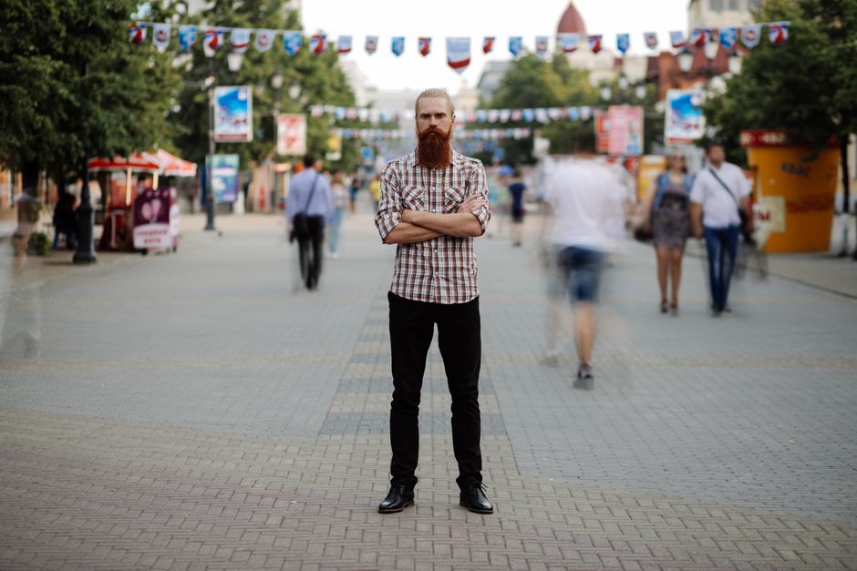 A sharply focused business person stands confidently while a crowd of people behind them is blurred, representing how an algorithm elevates one real estate agent above the competition.